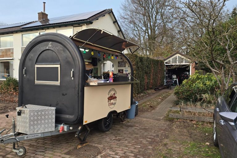 Stamtafel bedrijfsfeest Zwart-wit afbeelding vanSTAMtafel foodtruck op een binnenplaats tussen appartementen.